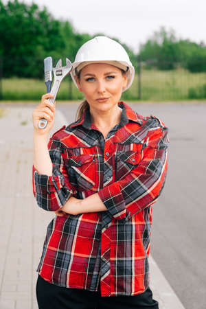 A brooding female builder with drawings of papers in her hands.の写真素材