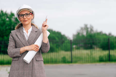 Portrait of a woman in an engineers protective mask with a pen pointing to the side.の写真素材