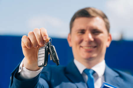 A closeup of a car key is held by a young man. Concept of buying a car.の写真素材