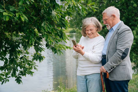 An elderly fashionable couple is photographed on a samrthon in the park.の写真素材