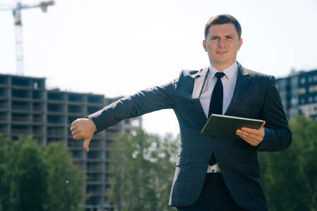 Stylish young man holds a digital tablet against the backdrop of the city background. Theの写真素材