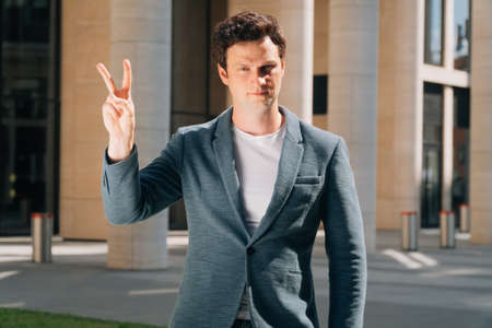 Stylish young man holds a digital tablet against the backdrop of the city background. Theの写真素材