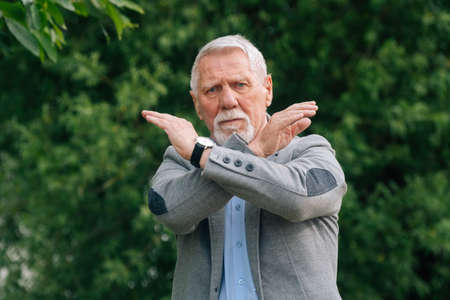 An elderly man in stylish clothes in nature. The concept of anger is a ban.の写真素材