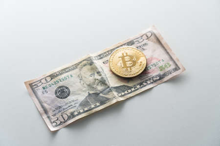 Biktcoin coin lies on paper dollar banknotes. Concept of virtual currency in exchange for cash.の写真素材