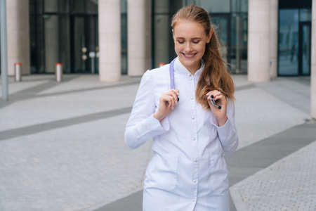 Portrait of a beautiful young girl in a white robe. Close up of womans happy smiling doctors faceの写真素材