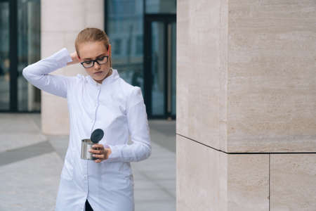 woman doctor holds an empty can for begging. The concept of a small salary for a nurseの写真素材