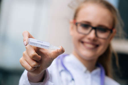 A scientist in sterile clothing holds a vaccineの写真素材