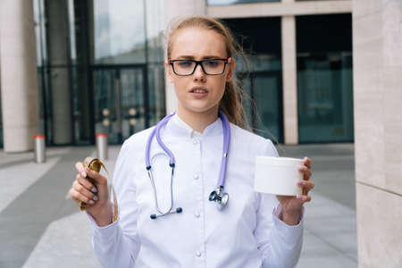 A portrait of a young doctor of a woman holding a jar of creamの写真素材