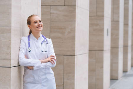 A young beautiful female doctor holds a stethoscope on an isolated white background.の写真素材