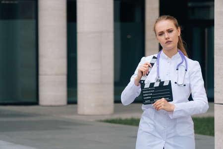 beautiful sad girl doctor with a smile holds a film strip in her hands.の写真素材