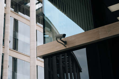 The ccTV camera is closeup against the background of the light business center.の写真素材