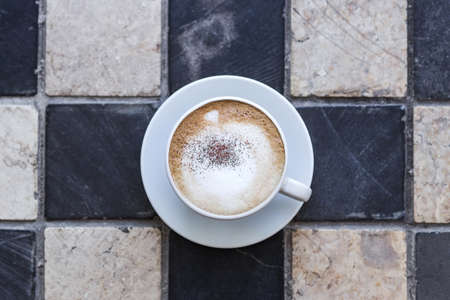 Cappuchino in white cup on stone squared backgroundの写真素材
