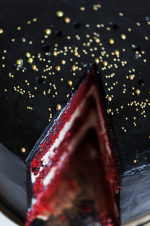 Round black cake with striped red and white fillingの写真素材