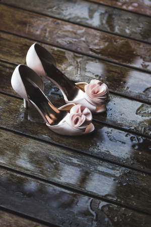 Bride wedding details. High heel shoes on wooden background with raindropsの写真素材