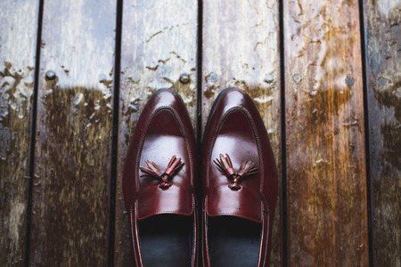 Groom wedding details. Leather shoes on wooden background with raindropsの写真素材