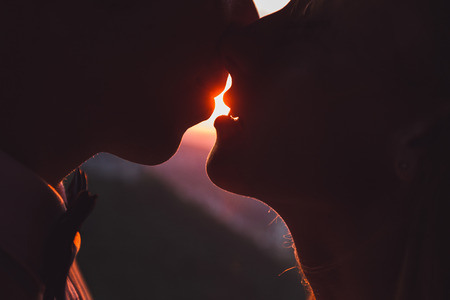 Intimate portrait of the bride and groom in front of the sunの写真素材