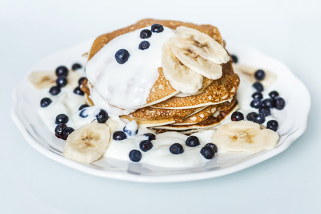 Homemade pancakes with banana, blueberries and sour creamの写真素材