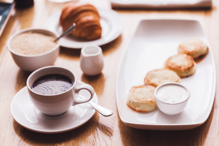 Breakfast: fresh coffee, croissant and cheese cakesの写真素材