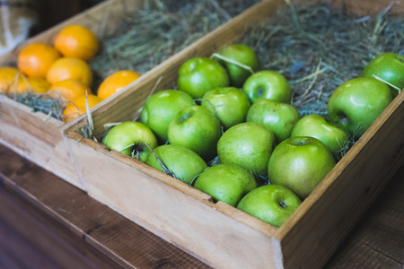Wooden box with fresh green apples on display in a fruit shopの写真素材