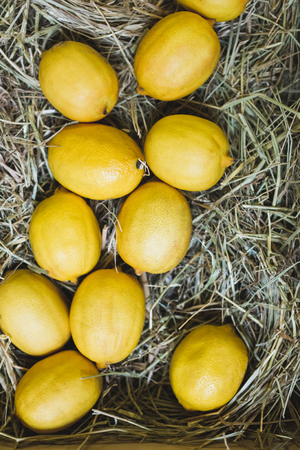 Wooden box with fresh ripe lemons on display in a fruit shop