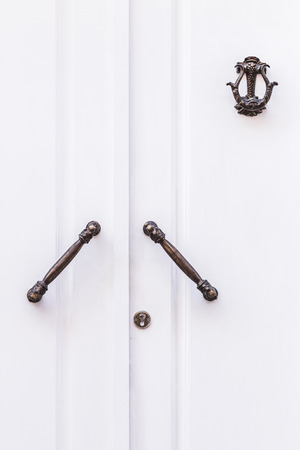 White door with beautiful carved metal handles and lockの写真素材