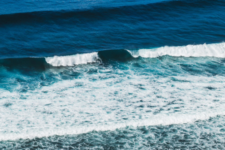 Ocean view from cliff coast, Bali sea landscape, look down from the height, surfing wave from above, Bali sea and surfing, high cliff and sea, jumping from cliffの写真素材