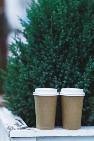 Two carton paper cups 
on a wooden shelf at the Christmas treeの写真素材