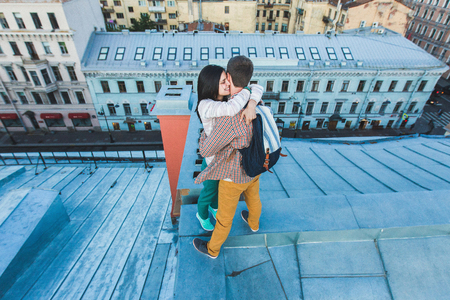 Young happy couple walking on the roofs of St. Petersburg. Beautiful view of the city from above. Casual styleの写真素材