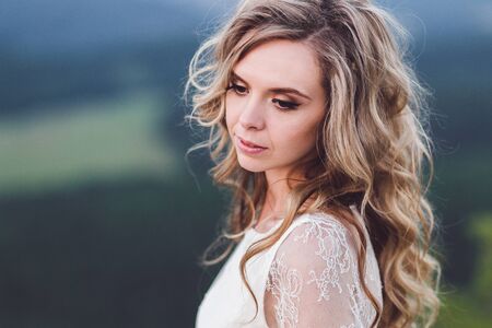 Natural portrait of woman with blonde curly hair outdoorsの写真素材