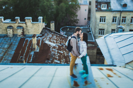 Young happy couple walking on the roofs of St. Petersburg. Beautiful view of the city from above. Casual styleの写真素材