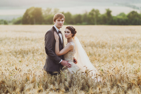 Loves couple in wheat field in sunlight. Romantic feelings at sunsetの写真素材
