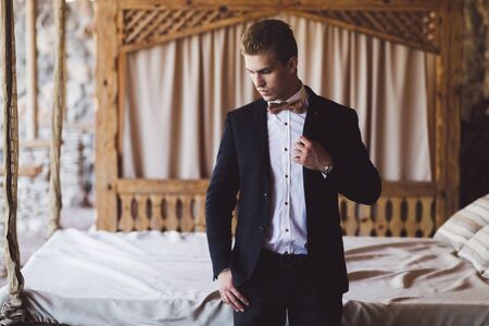 Portrait of elegant handsome man in black suit and bow-tie. Male fashion modelの写真素材