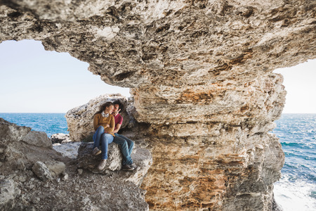 Couple enjoying together on rocky coast at sunset light. Tarhankut, Crimeaの写真素材