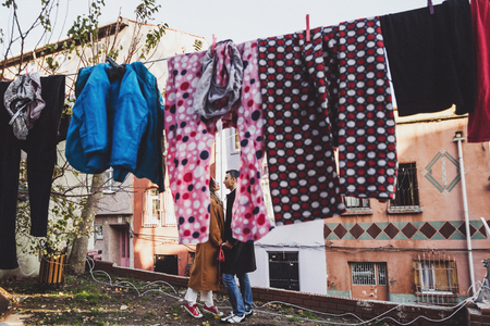 Young couple having fun in drying laundry hanging at old streets of Istanbul in Balatの写真素材