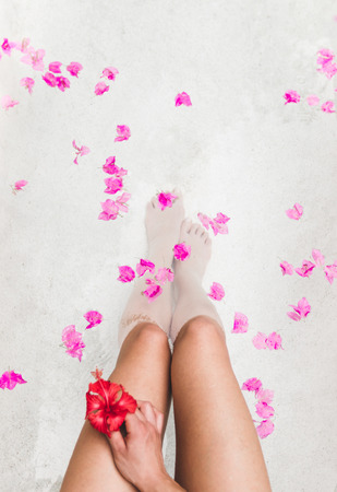 Woman relaxing in round outdoor bath with tropical flowers, organic skin care, luxury spa hotel, lifestyle photoの写真素材