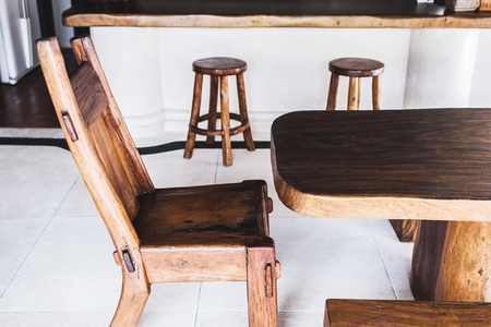 Vintage handmade wooden bar stools are lined up at an outdoor cafe on white backgroundの写真素材