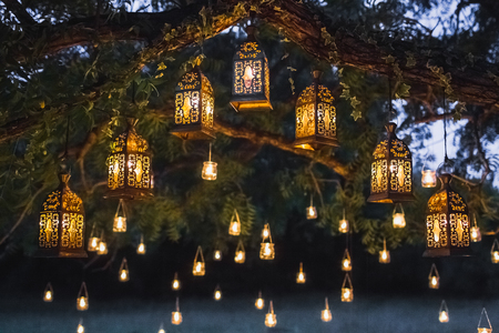 Night wedding ceremony with a lot of vintage lamps and candles on big treeの写真素材