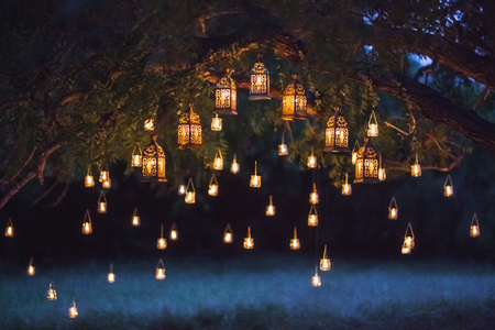 Night wedding ceremony with a lot of vintage lamps and candles on big treeの写真素材