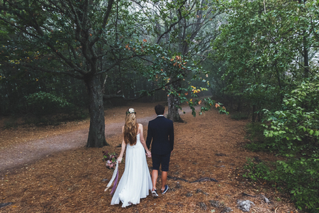 Bride and groom walking in autumn forest. Amazing autumn fog and  mystery mood. Beautiful nature aroundの写真素材