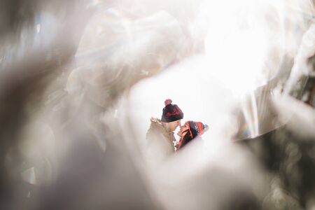 Close and emotional portrait of loving couple at winter. Through flickering bokeh