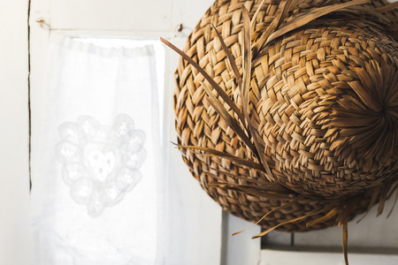 Texture of straw hat Bali style hanging on white wall close upの写真素材