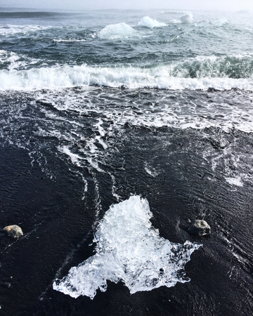Iceland Glacier Lagoon Jokulsarlon on Vatnajokull. Foggy weather, black volcanic beach with a piece...