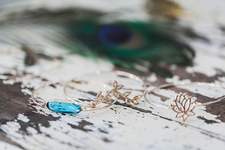 Golden jewelry bracelet with blue gemstone on wooden shabby backgroundの写真素材