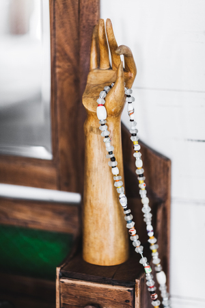 Wooden hand as handmade decoration in Bali style with hanging beads of multi-colored stonesの写真素材
