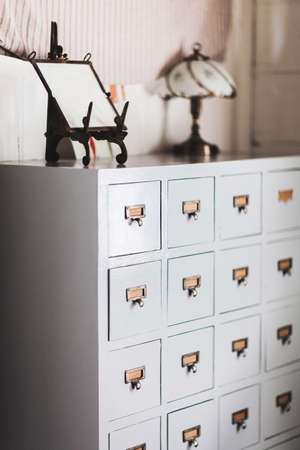 Wooden vintage cupboard with a lot of repeated small bronze lockers. Frame and lamp no topの写真素材