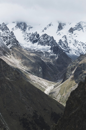 Snow mountain peaks of Caucasus mountains in cold cloudy weather, Elbrus Region. Main caucasian ridgeの写真素材