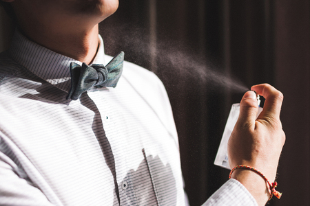 Man applies perfume and smells fragranceの写真素材