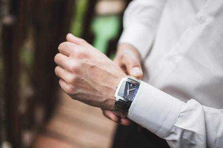 Man in white shirt wearing classic silver watches. Getting ready for weddingの写真素材