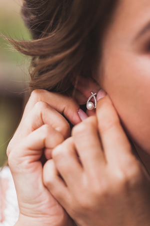 Woman wearing earrings with pearl close-upの写真素材