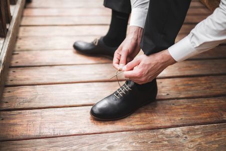 Man wearing brown leather classic shoes, black trousers and white shirt, business styleの写真素材